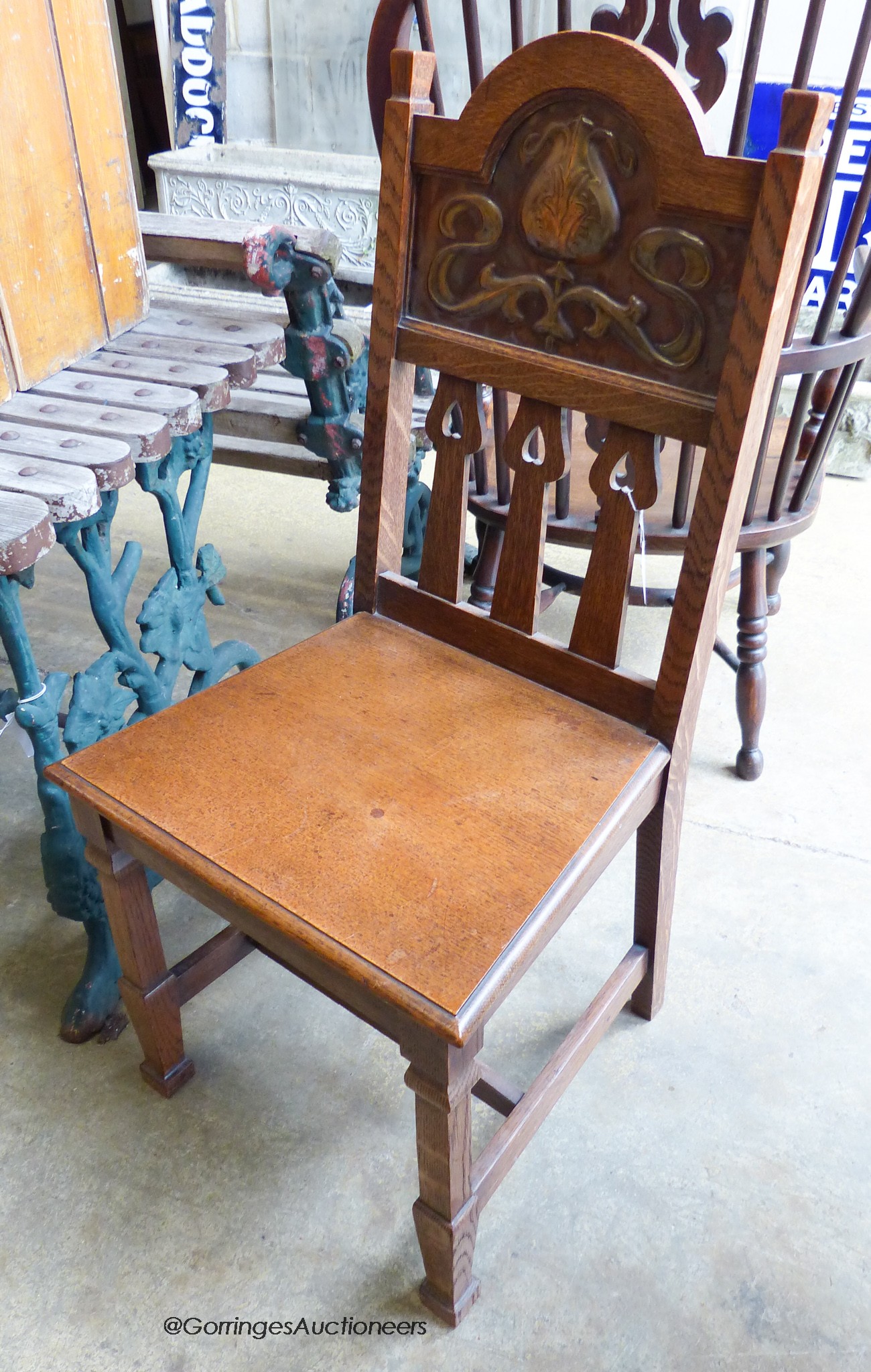 An Arts and Crafts oak and embossed copper hall chair.